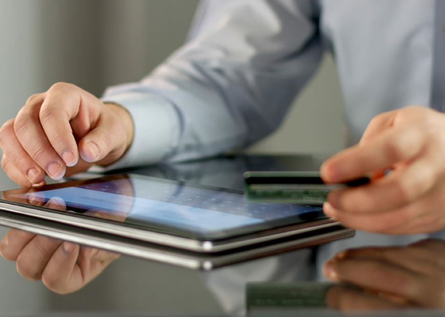 image of person using credit card and tablet