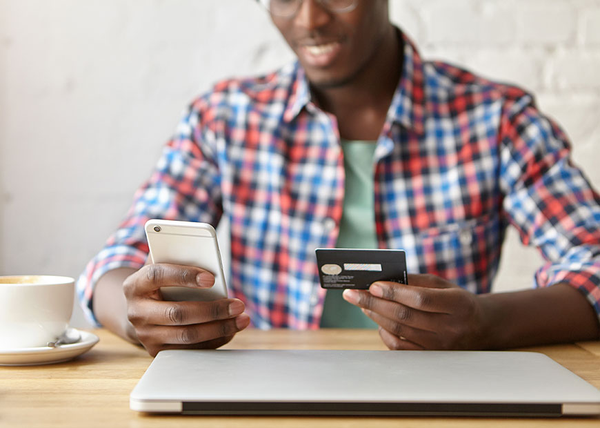 image of man using credit card and phone