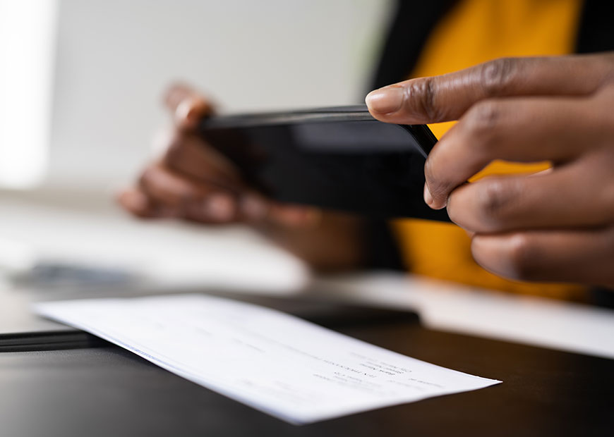 image of person taking a photo of a check with a phone