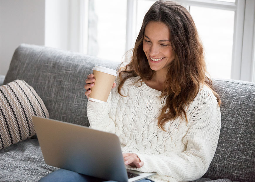 image of woman with coffee looking at computer