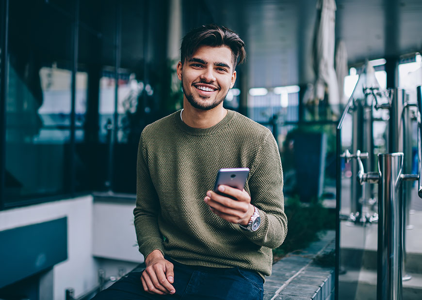 image of smiling man holding phone