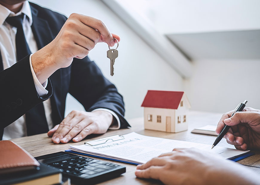 image of man handing keys over to new homeowner signing papers