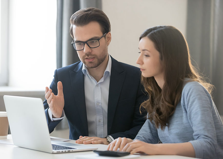 image of two people looking at laptop